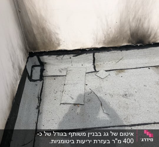פינות גג עם איטום זפת שחור וסדקים קטנים